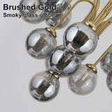 Close-up brushed gold curved arm smoky mirror glass globe lampshade chandelier detail shot