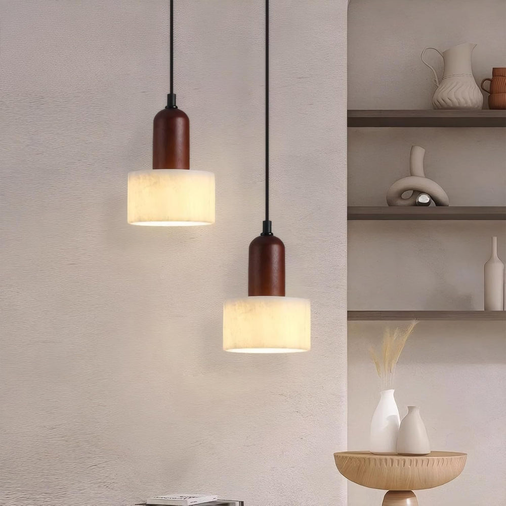 Two marble wood cylinder pendant lights on textured wall.