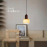 Single stone wood pendant light in minimalist corner.