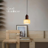 Single stone wood pendant light in minimalist corner.