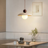 Travertine pendant light above wooden dining table