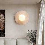 Natural travertine round wall sconce with warm light in living room