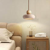 Natural travertine wood pendant light over bedside table, warm LED glow