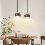 Two Yellow Travertine & Wood Pendant Lights Hanging Above a Wooden Dining Table - Rustic Organic Kitchen Lighting Idea