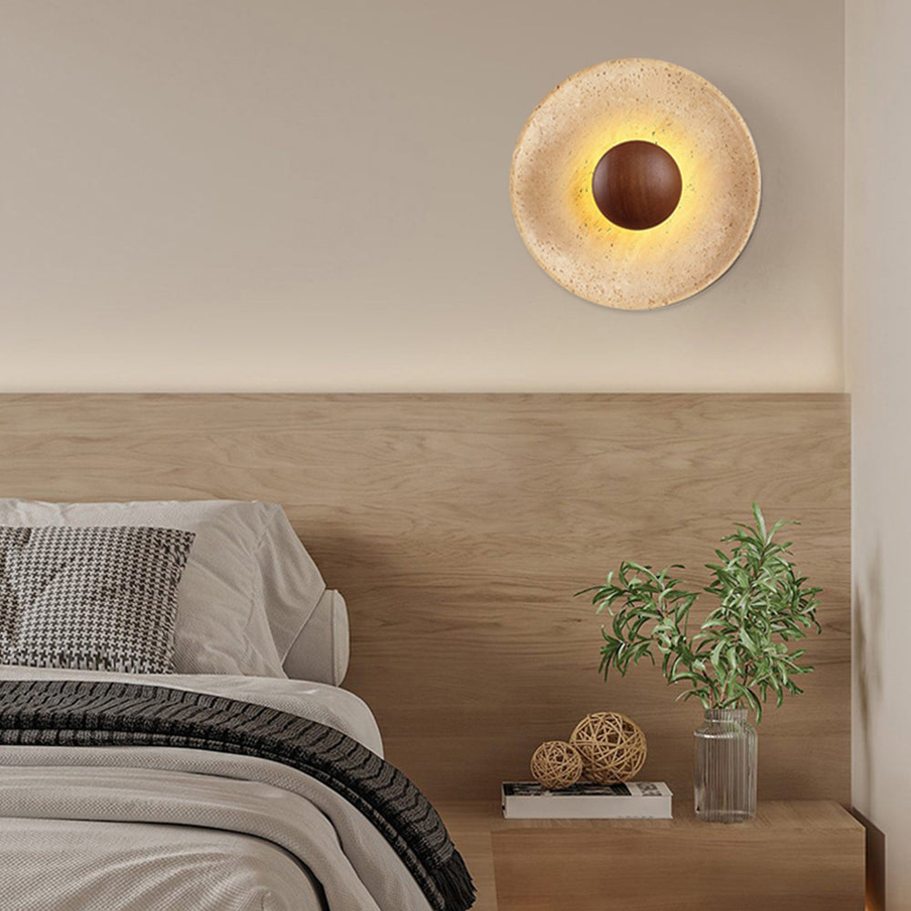 Wabi sabi travertine wall light above wooden bed headboard