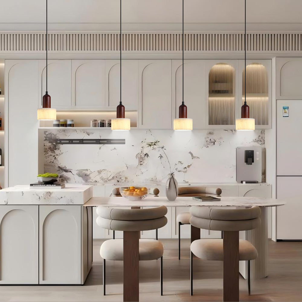 Four marble pendant lights over modern kitchen island.