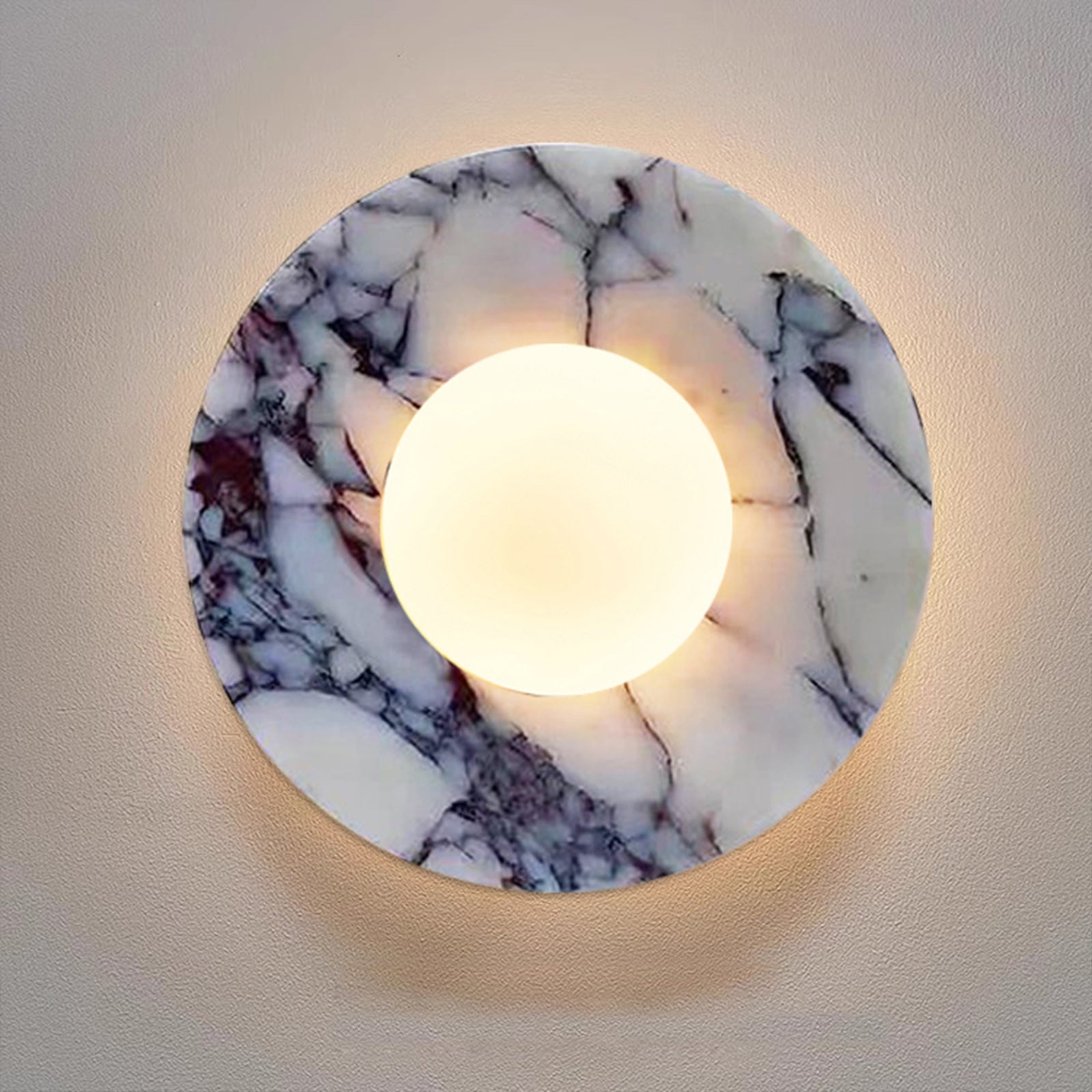 Close-up view of marble wall sconce with glass globe