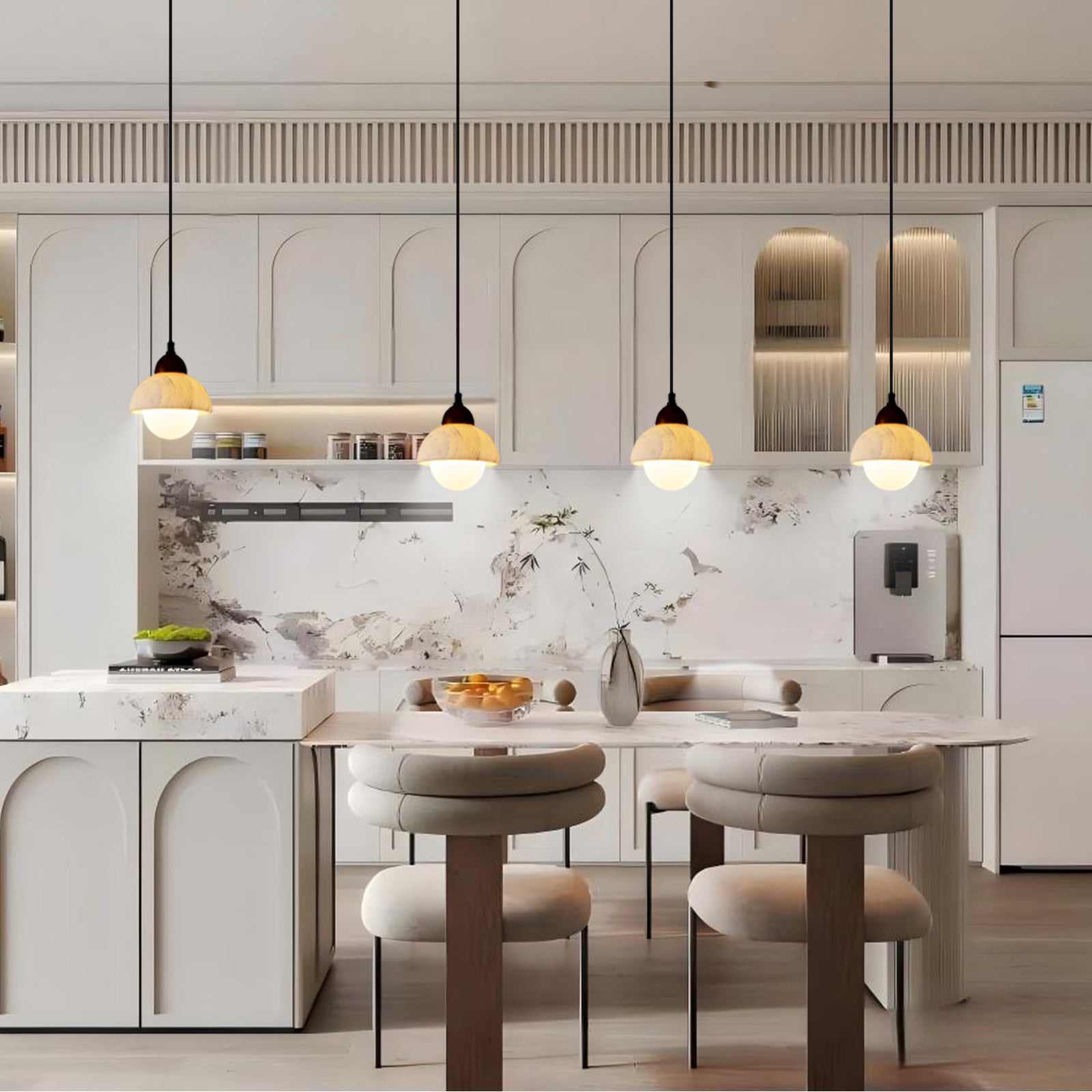 Four marble pendant lights hanging above a kitchen island in a bright white kitchen