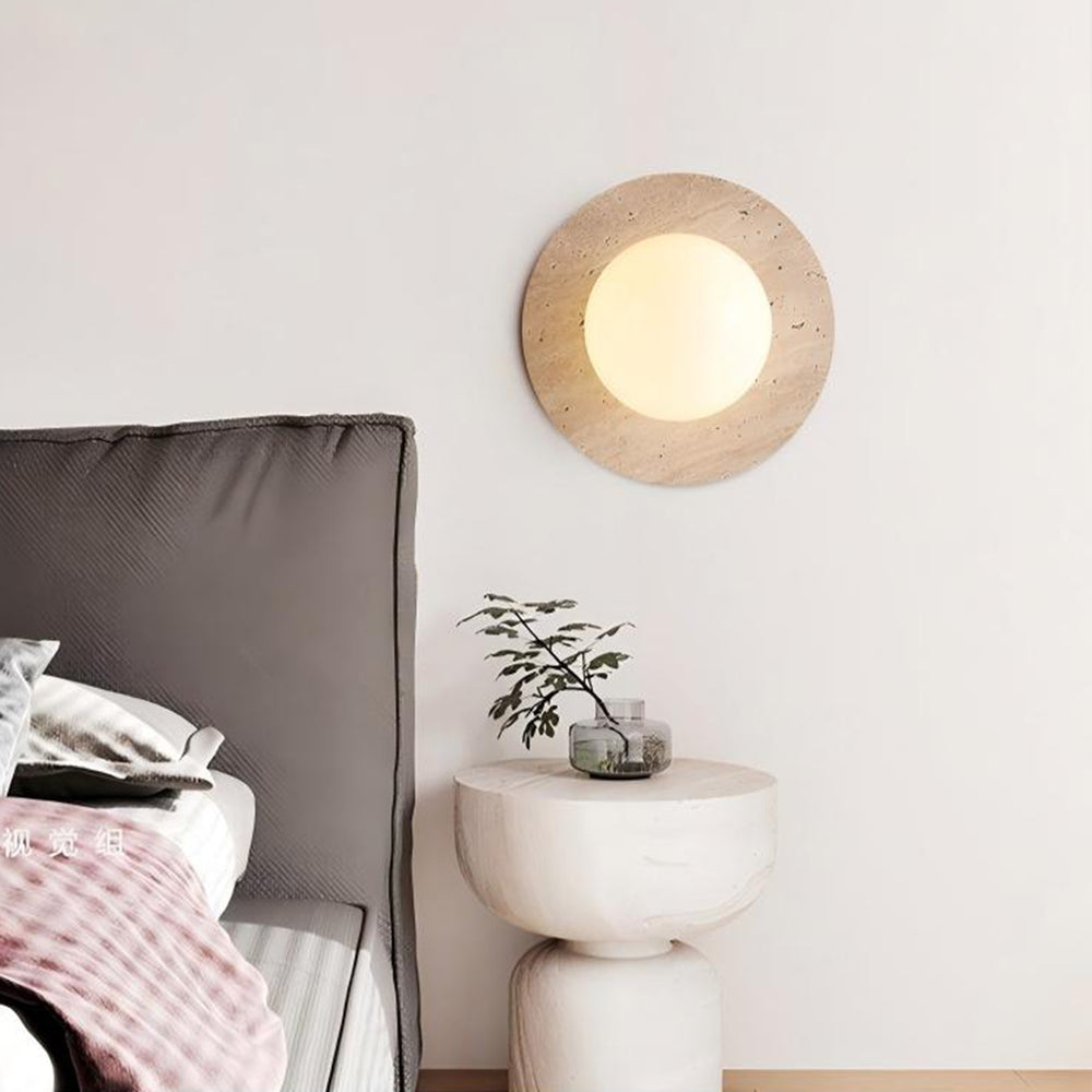 Wabi sabi travertine wall light above bedside table, cozy bedroom