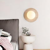 Wabi sabi travertine wall light above bedside table, cozy bedroom