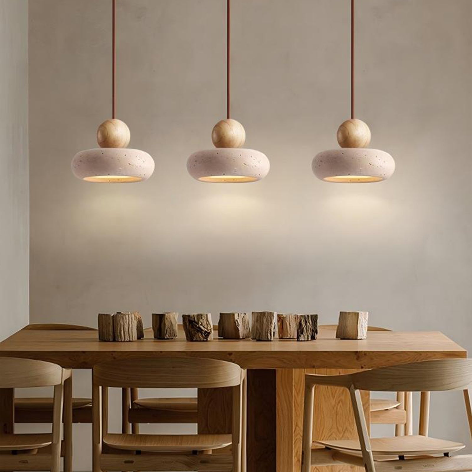 hree travertine pendant lights above wooden dining table, wabi sabi style