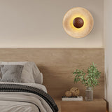 Wabi sabi travertine wall light above wooden bed headboard