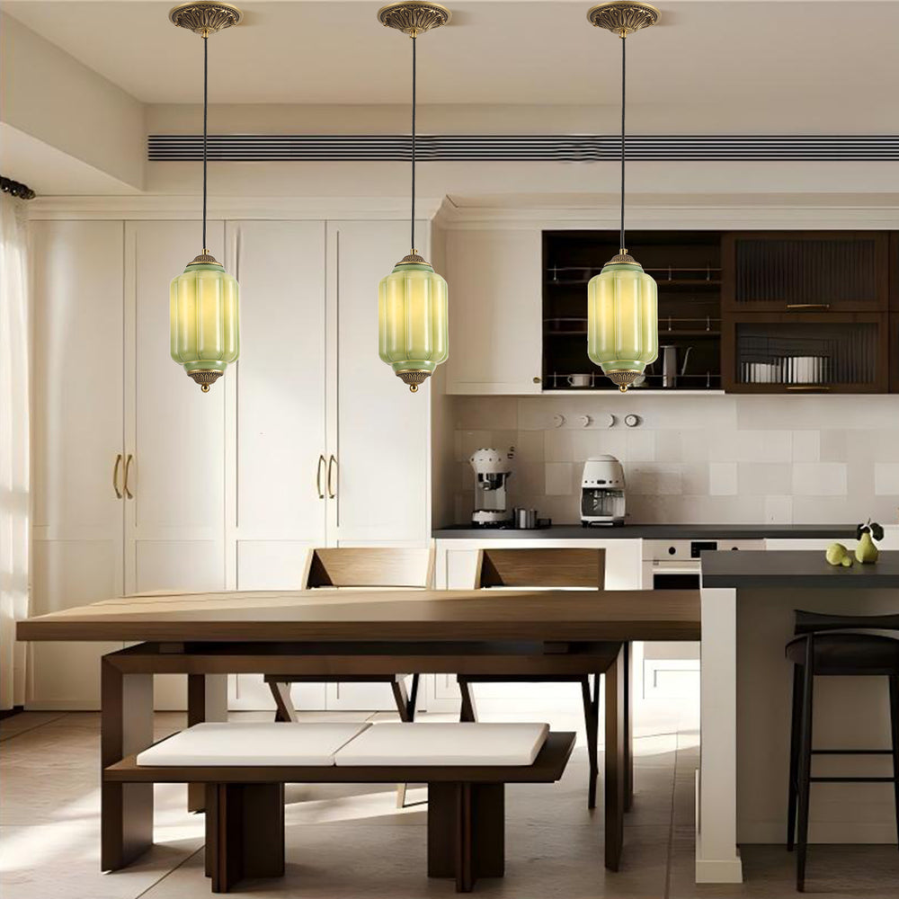 Vintage green ceramic pendant lights above a wooden dining table in a modern kitchen