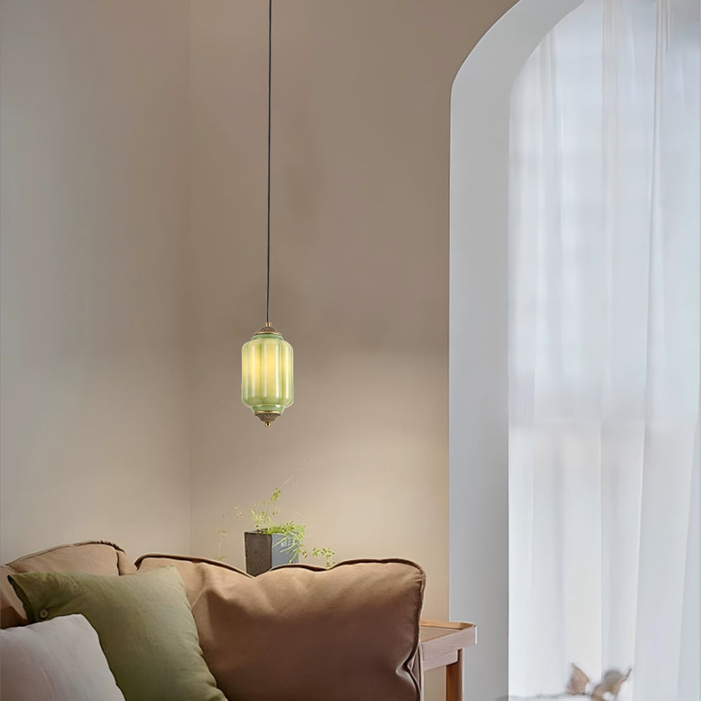 Green ceramic pendant lamp in a cozy living room with arched window