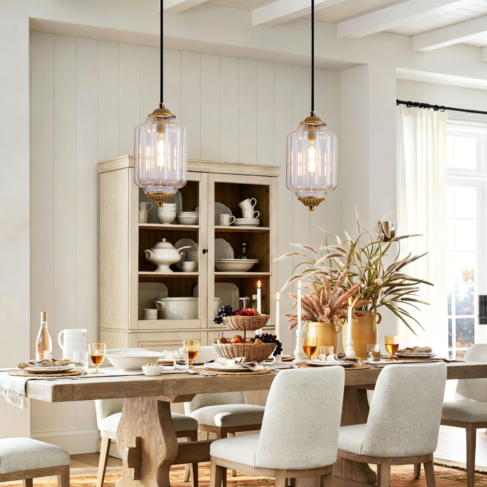 Two vintage clear glass bronze pendant lights over farmhouse wooden dining table